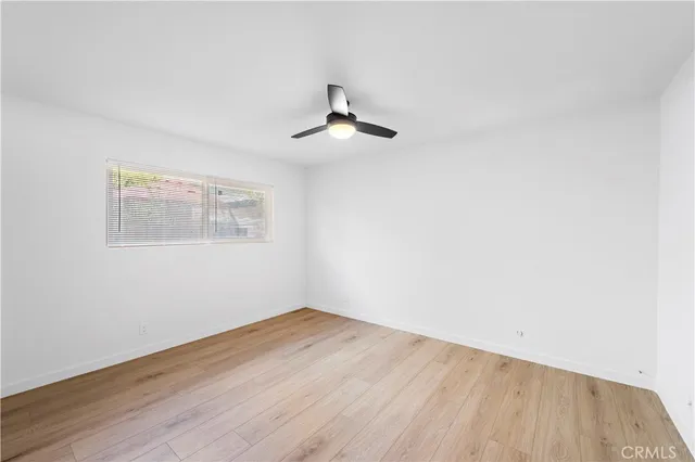 an empty room with a window and ceiling fan