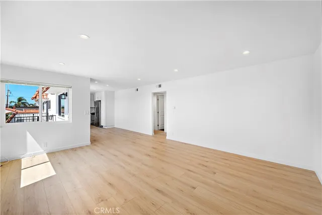 a view of a big room with wooden floor and windows