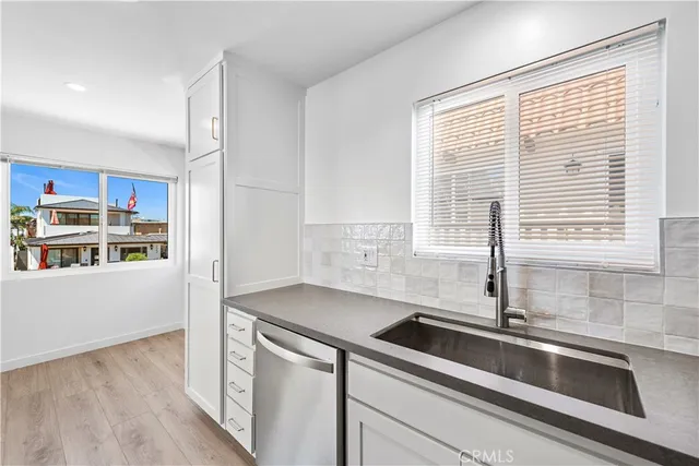a view of a kitchen with a refrigerator a stove top oven and wooden floor