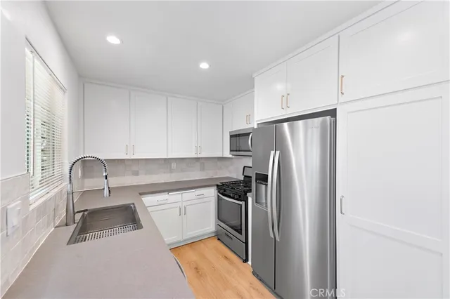 a kitchen with stainless steel appliances a refrigerator sink and cabinets