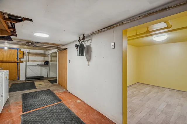 a view of a hallway with wooden floor and a bathroom