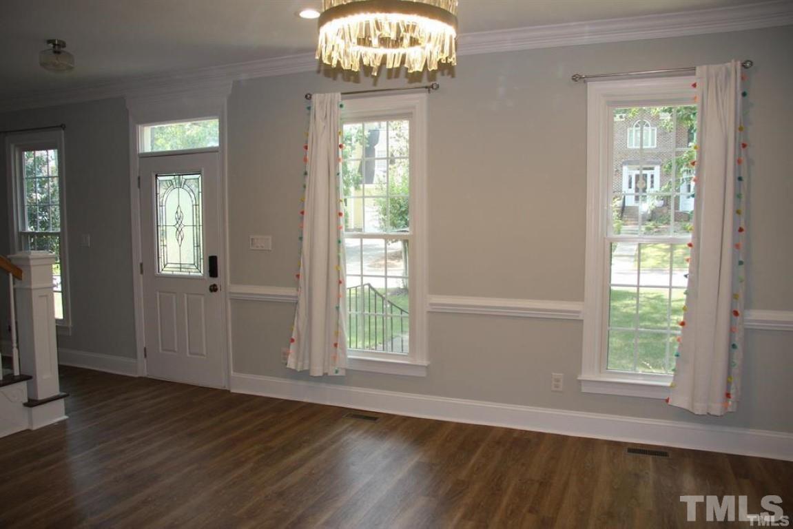 204 Morrow Mountain Drive Cary, NC 27513 - Photo 4 of 40 an empty room with wooden floor fan and windows