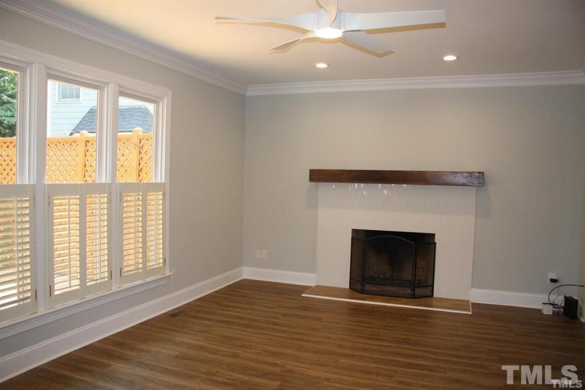 204 Morrow Mountain Drive Cary, NC 27513 - Photo 9 of 40 an empty room with wooden floor fireplace and windows
