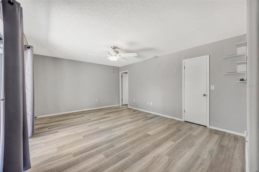 10199 Elgin Boulevard Spring Hill, FL 34608 - Photo 13 of 66 a view of an empty room with wooden floor and a window