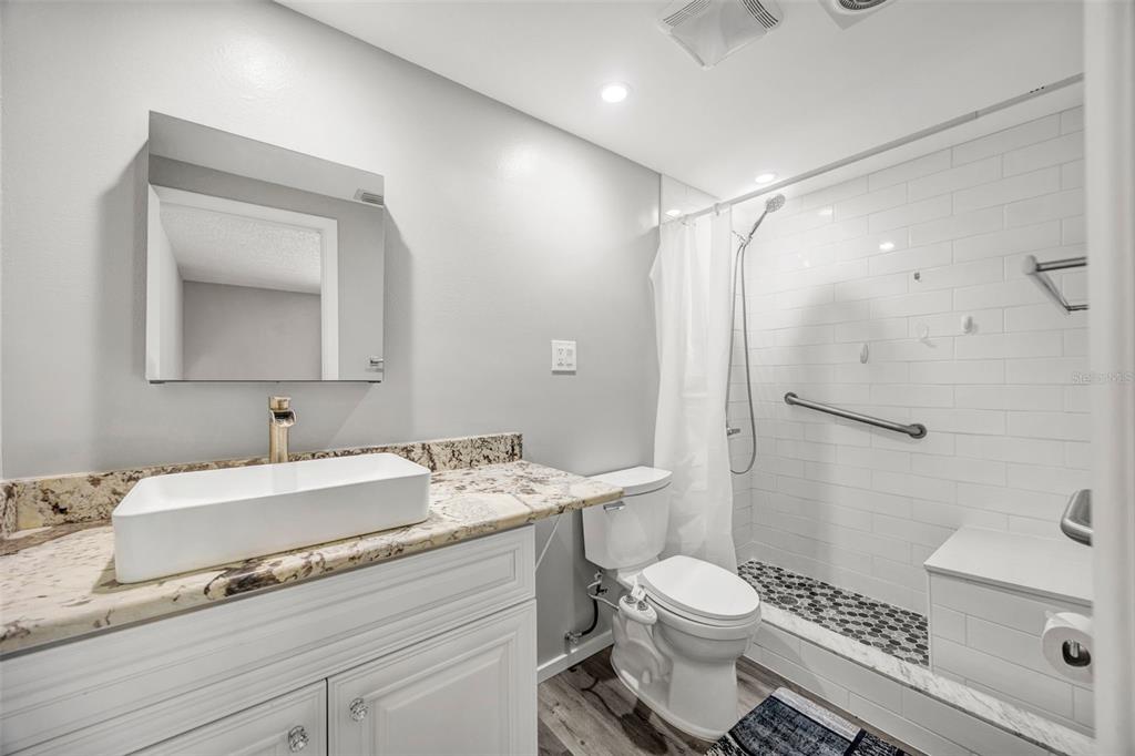 10199 Elgin Boulevard Spring Hill, FL 34608 - Photo 16 of 66 a bathroom with a sink toilet vanity and shower