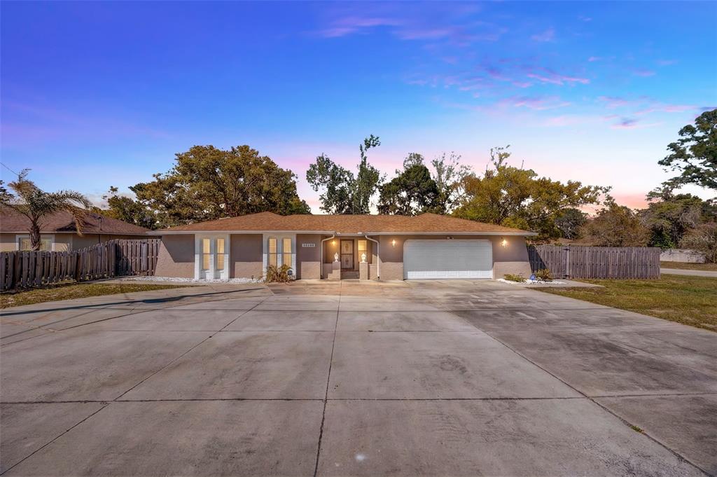 10199 Elgin Boulevard Spring Hill, FL 34608 - Photo 2 of 66 a view of a yard in front of a house with large trees