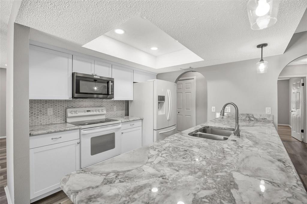 10199 Elgin Boulevard Spring Hill, FL 34608 - Photo 23 of 66 a kitchen with stainless steel appliances granite countertop a stove a sink and a microwave