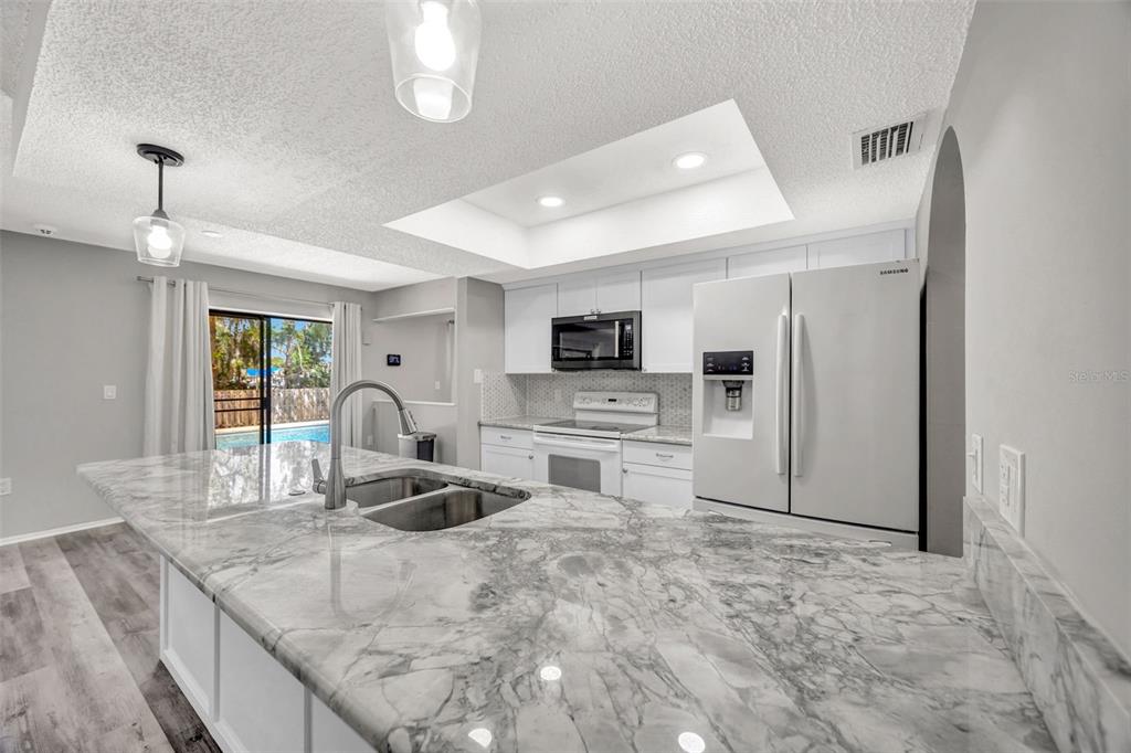 10199 Elgin Boulevard Spring Hill, FL 34608 - Photo 26 of 66 a kitchen with stainless steel appliances granite countertop a sink refrigerator stove and microwave