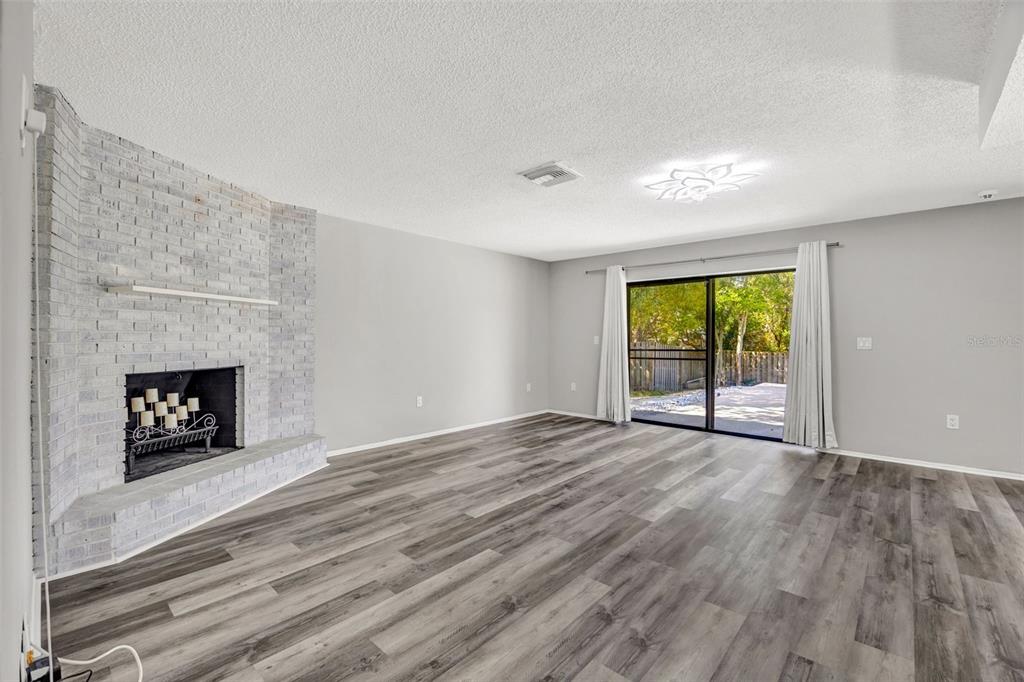 10199 Elgin Boulevard Spring Hill, FL 34608 - Photo 30 of 66 an empty room with windows and fireplace