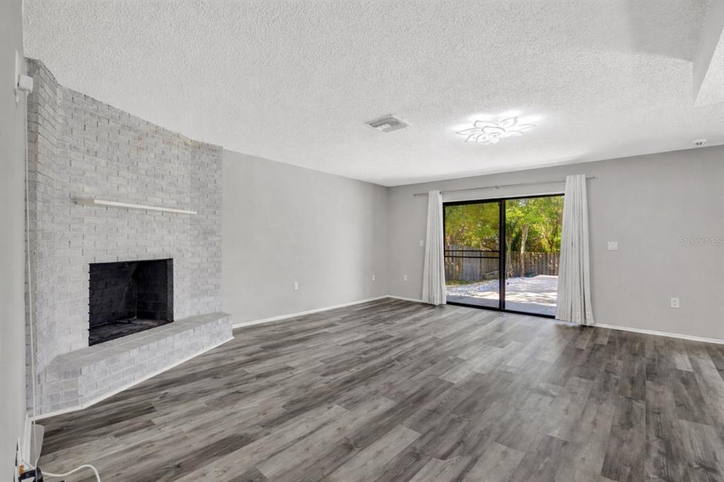10199 Elgin Boulevard Spring Hill, FL 34608 - Photo 31 of 66 wooden floor fireplace and natural light in room