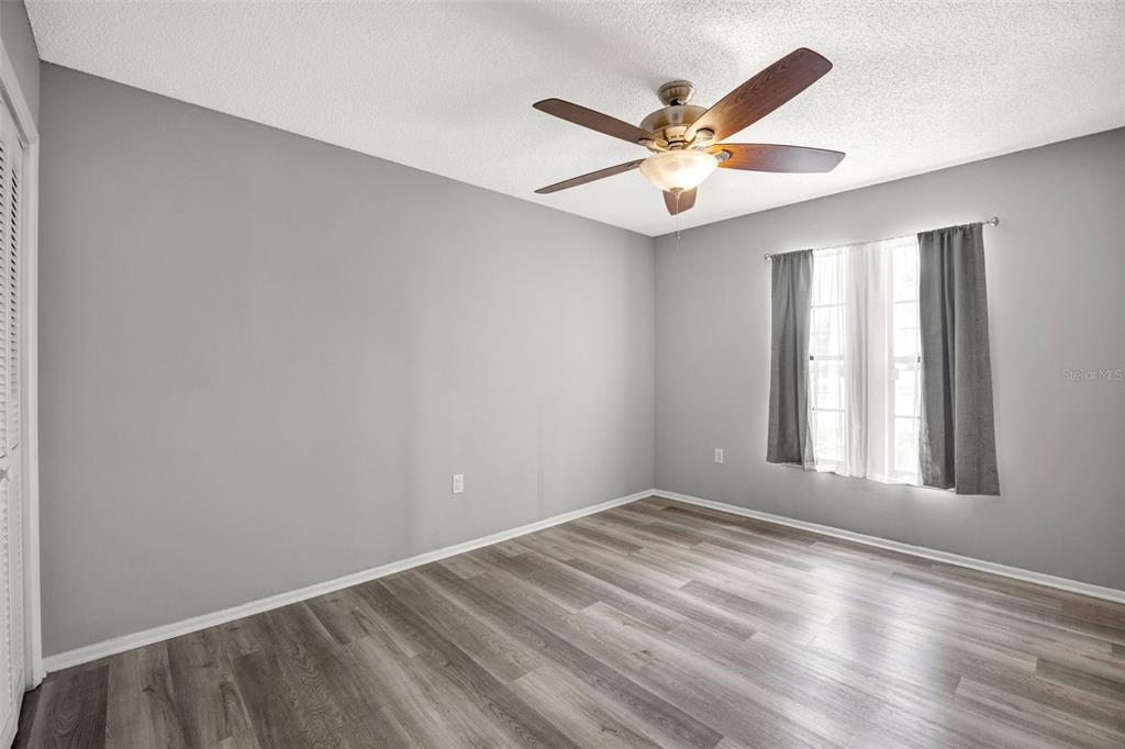 10199 Elgin Boulevard Spring Hill, FL 34608 - Photo 35 of 66 an empty room with wooden floor fan and windows