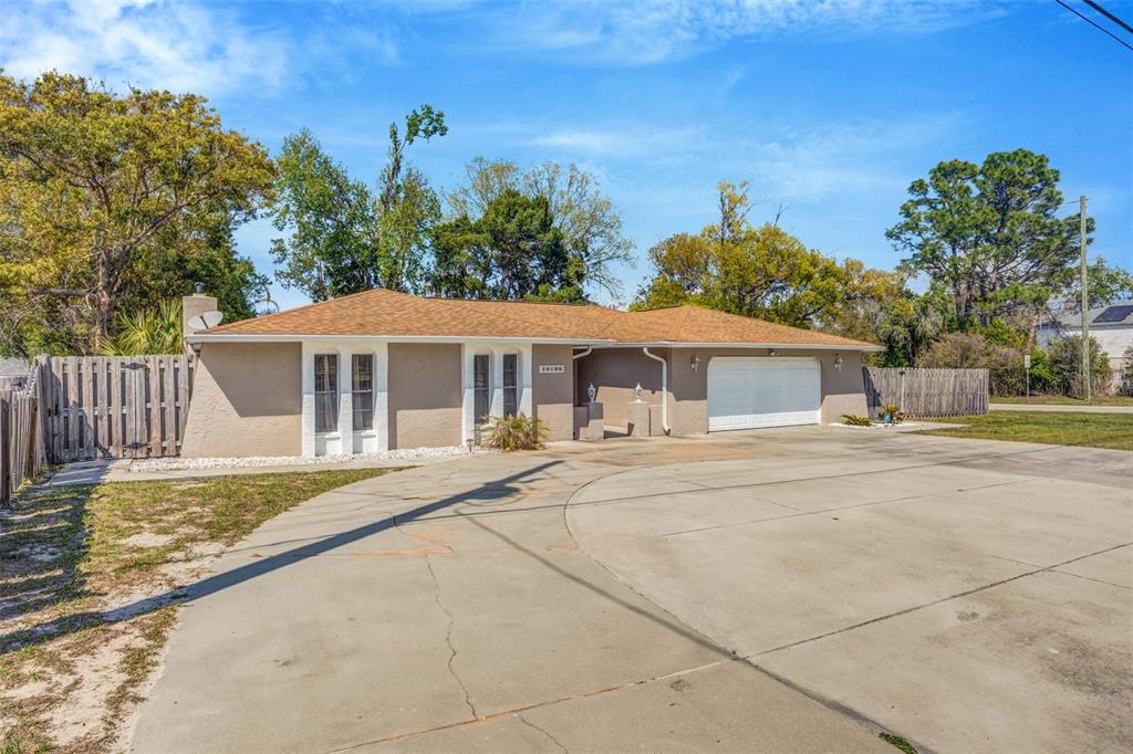 10199 Elgin Boulevard Spring Hill, FL 34608 - Photo 4 of 66 a front view of a house with a yard and trees