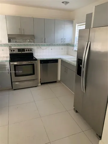 a kitchen with a stove a refrigerator and cabinets