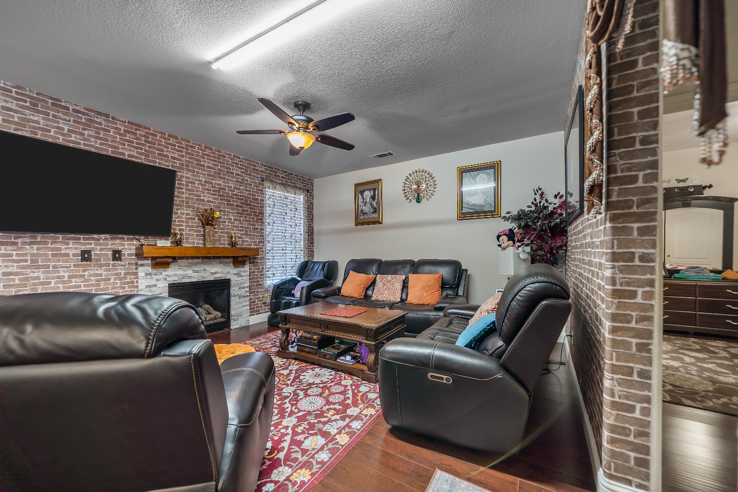 1114 Kay Circle Turlock, CA 95382 - Photo 12 of 40 a living room with furniture a flat screen tv and a fireplace