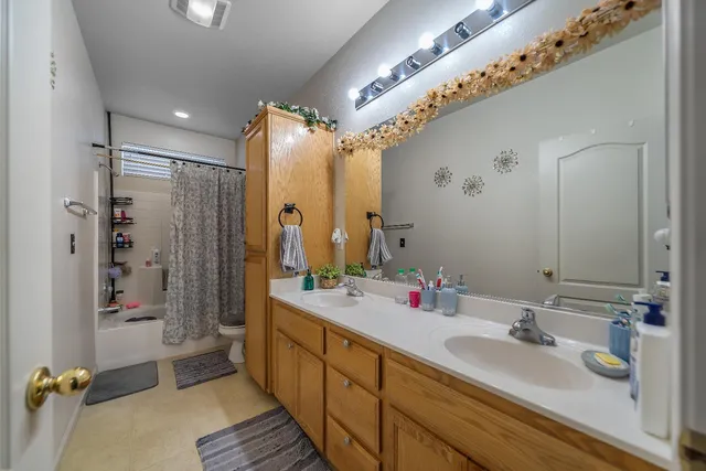 a bathroom with a double vanity sink mirror and shower