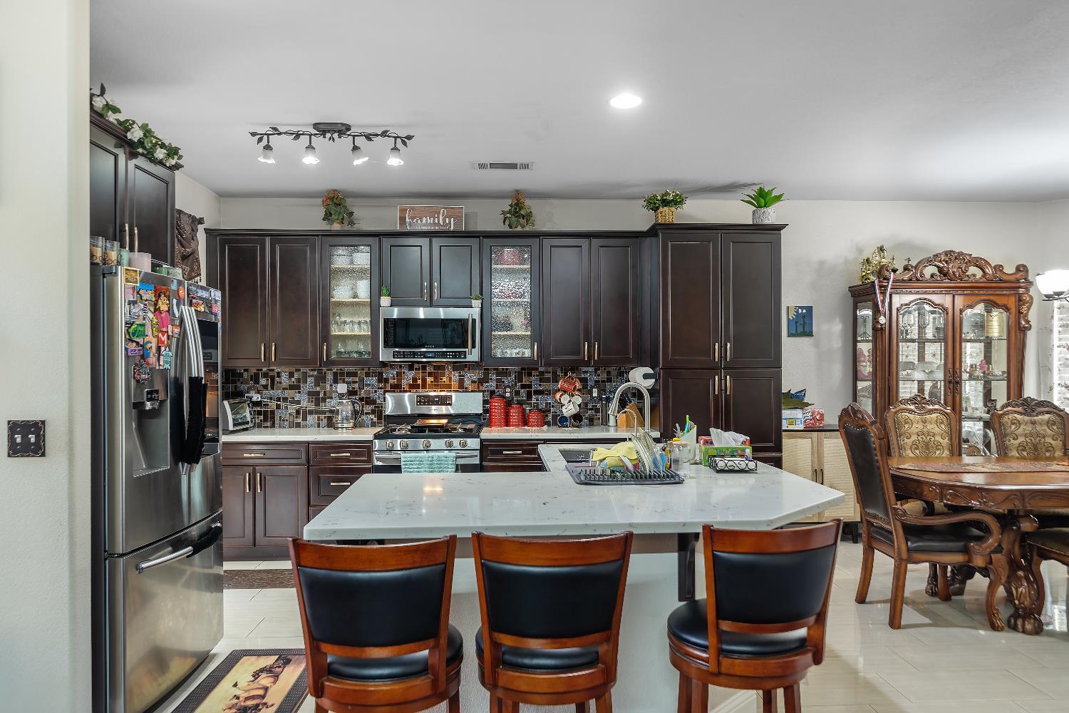 1114 Kay Circle Turlock, CA 95382 - Photo 18 of 40 a dining hall with granite countertop a stove and chairs