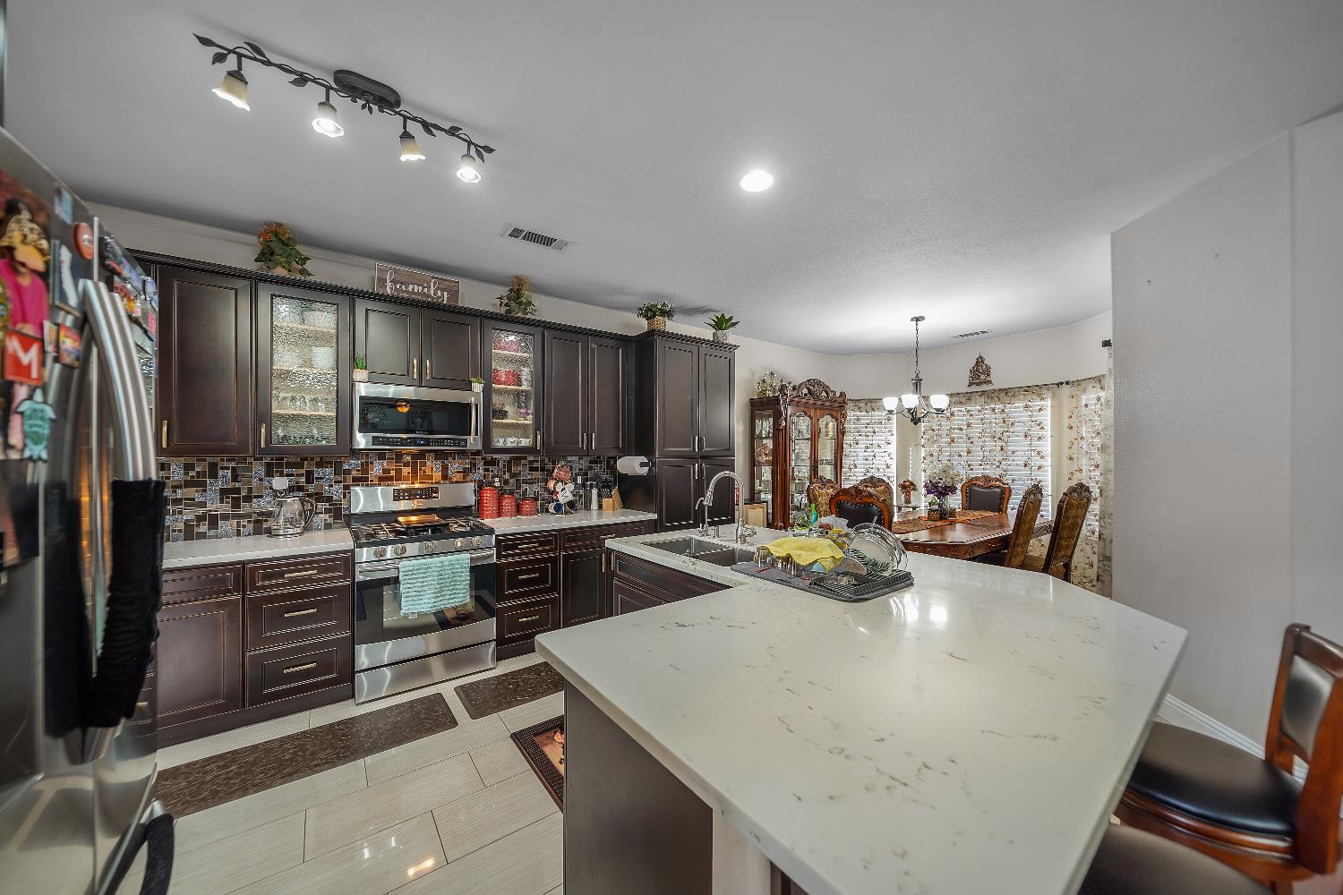 1114 Kay Circle Turlock, CA 95382 - Photo 19 of 40 a kitchen with kitchen island a stove and a refrigerator