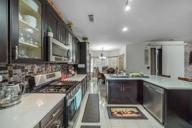 a kitchen with stainless steel appliances a sink stove and cabinets