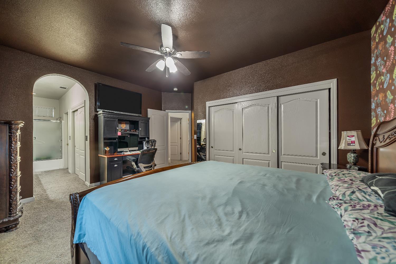 1114 Kay Circle Turlock, CA 95382 - Photo 31 of 40 a spacious bedroom with a bed and a flat screen tv