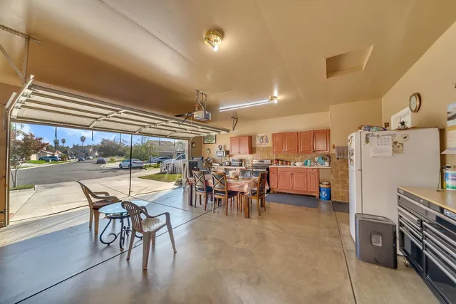 a room with lots of wooden furniture and stainless steel appliances