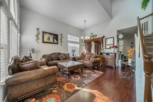 a living room with furniture a chandelier and a window