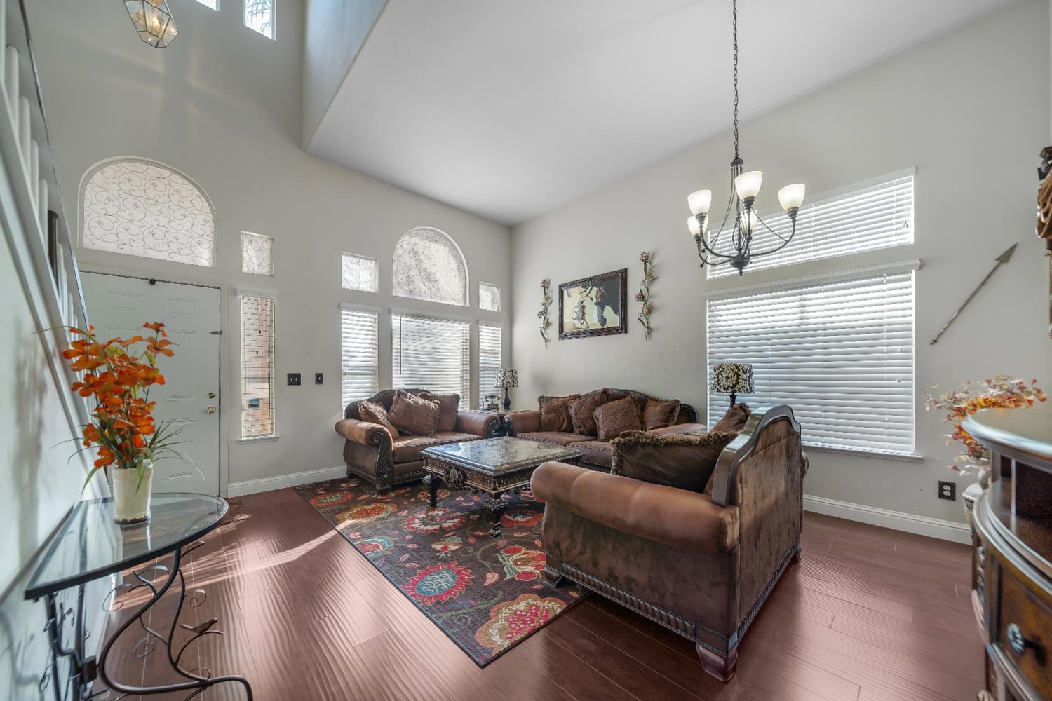 1114 Kay Circle Turlock, CA 95382 - Photo 8 of 40 a living room with furniture a chandelier and a flat screen tv