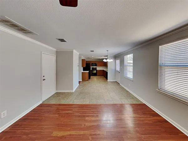 a view of empty room with wooden floor
