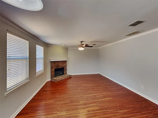 a view of a livingroom with a fireplace a ceiling fan and window