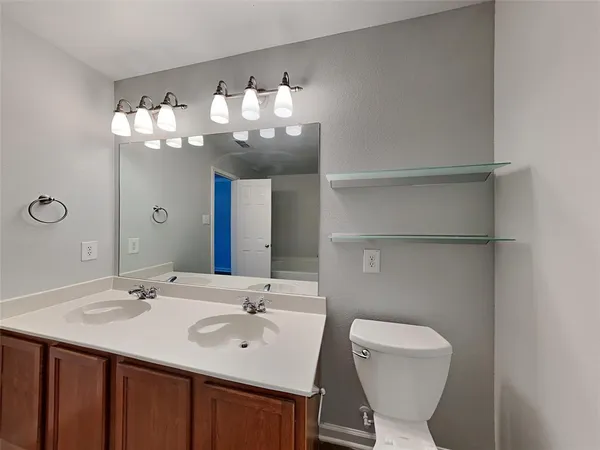 a bathroom with a toilet sink and mirror