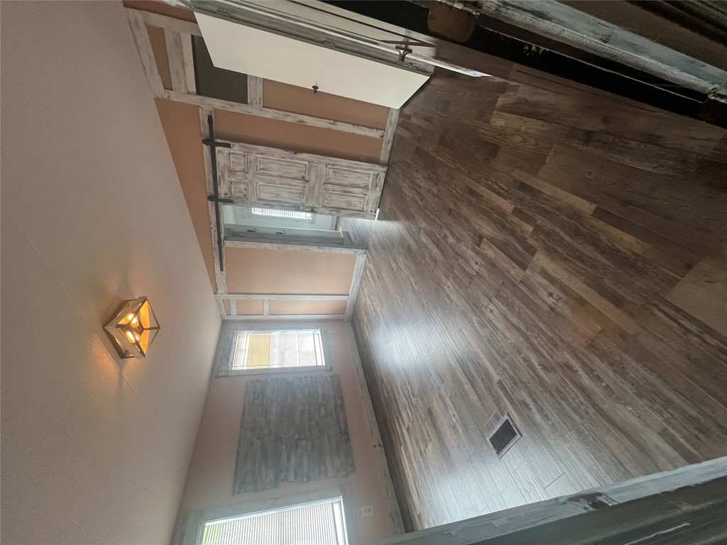 106 Bridle Path, Unit B Kyle, TX 78640 - Photo 12 of 25 a view of an empty room with wooden floor and a window