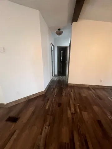 a view of a big room with wooden floor and windows