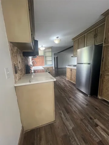 a kitchen with stainless steel appliances a refrigerator a sink a stove a microwave and wooden floor