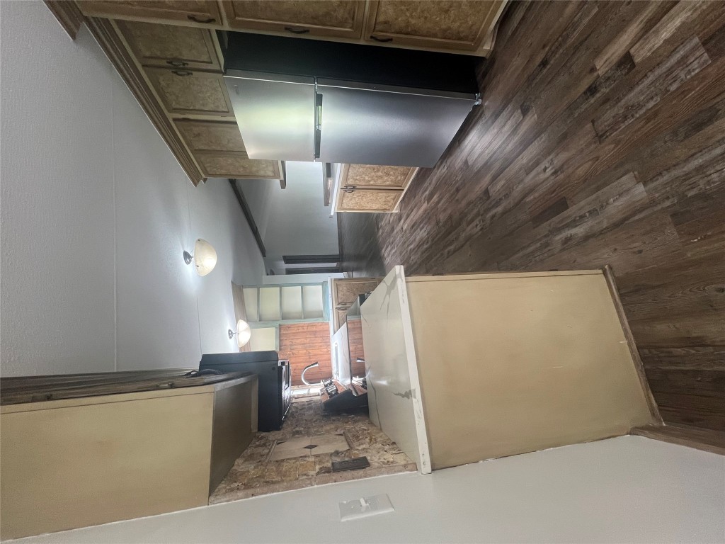 106 Bridle Path, Unit B Kyle, TX 78640 - Photo 3 of 25 a kitchen with stainless steel appliances a refrigerator a sink a stove a microwave and wooden floor