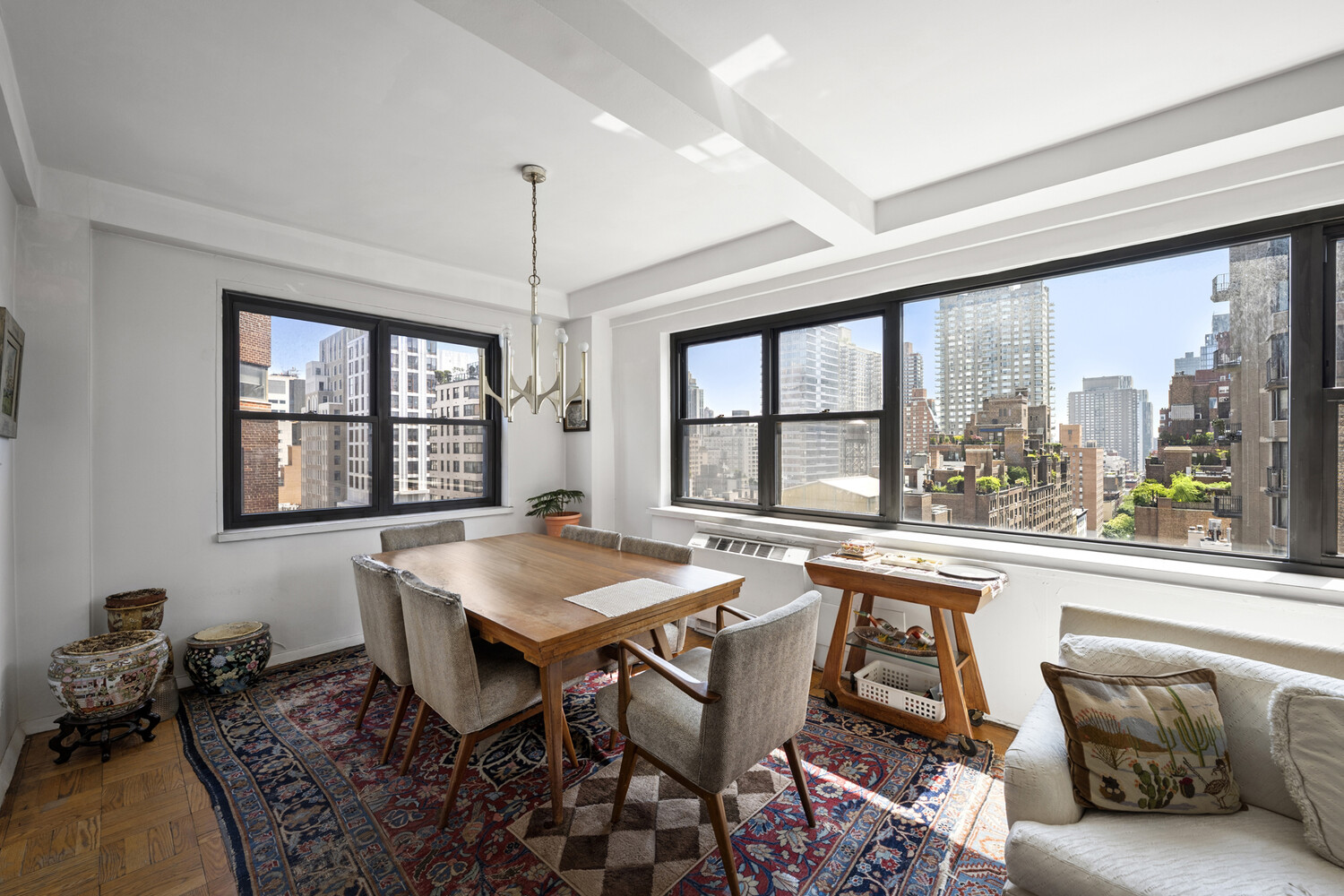165 East 72nd Street, Unit 12J Manhattan, NY 10021 - Photo 3 of 13 a view of a dining room with furniture large windows and wooden floor