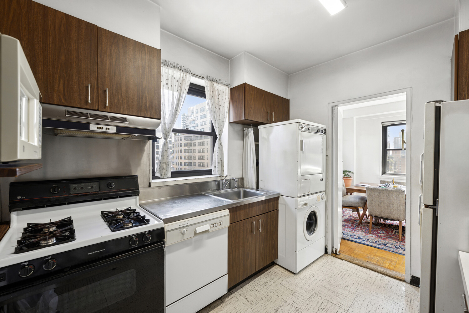 165 East 72nd Street, Unit 12J Manhattan, NY 10021 - Photo 4 of 13 a kitchen with a stove and a refrigerator
