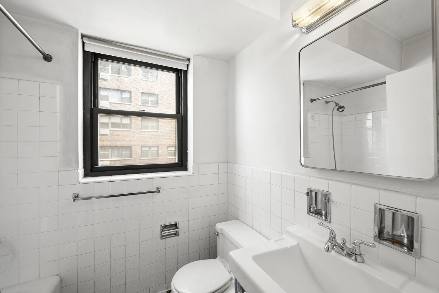 165 East 72nd Street, Unit 12J Manhattan, NY 10021 - Photo 5 of 13 a bathroom with a toilet sink and mirror