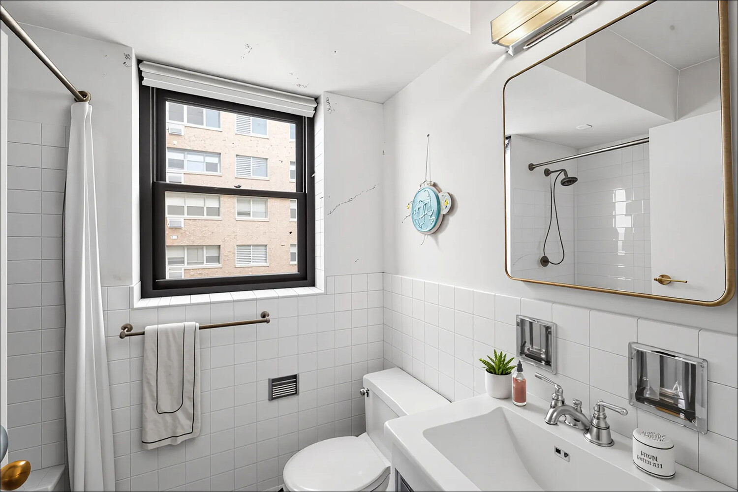 165 East 72nd Street, Unit 12J Manhattan, NY 10021 - Photo 6 of 13 a bathroom with a toilet sink and mirror