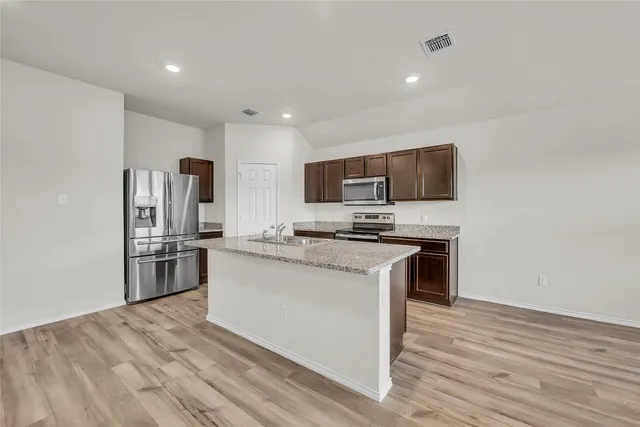 a view of kitchen with microwave oven stove and cabinets