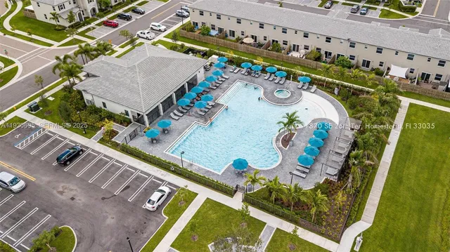 an aerial view of swimming pool playground and residential houses with outdoor space
