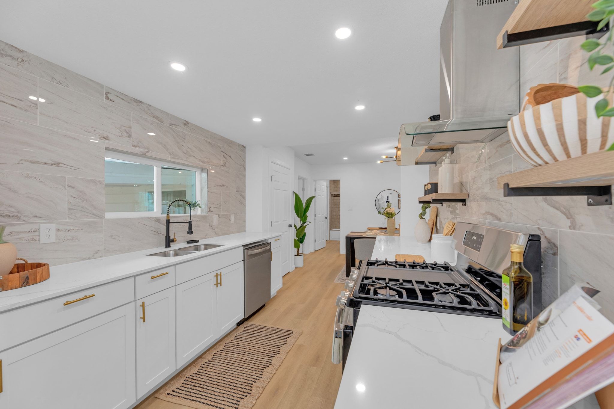 1709 Cecelia Street Taylor, TX 76574 - Photo 15 of 38 Kitchen featuring open shelves, white cabinetry, light stone counters, extractor fan, and stainless steel appliances