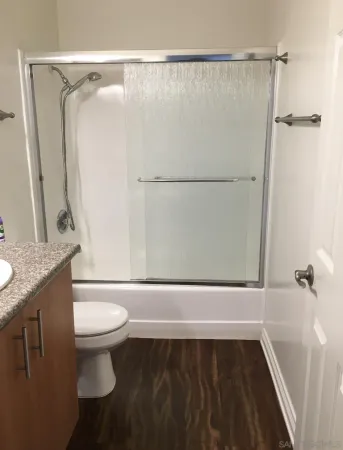 a bathroom with a granite countertop sink toilet and shower