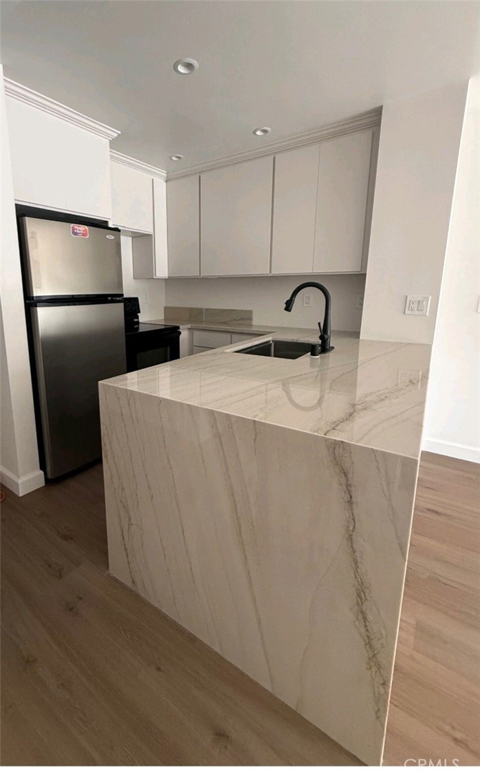 a view of kitchen with stainless steel appliances granite countertop refrigerator sink and stove