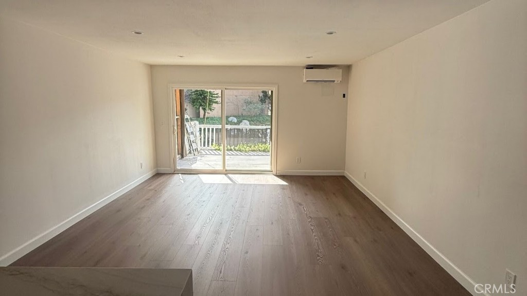 7890 East Spring Street Long Beach, CA 90815 - Photo 2 of 8 wooden floor in an empty room with a window