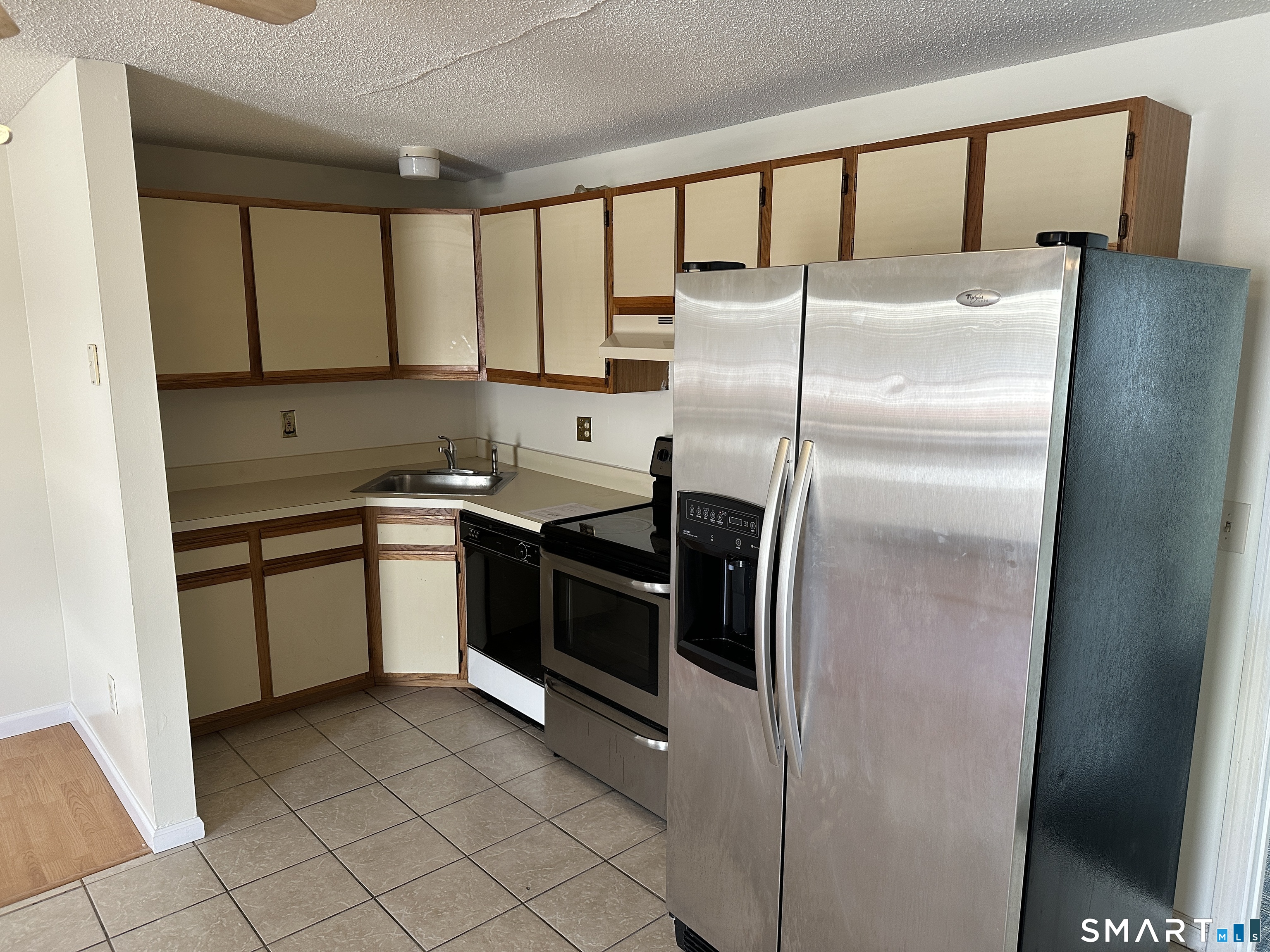 114 Bucks Hill Road, Unit 4 Waterbury, CT 06704 - Photo 5 of 12 a kitchen with a refrigerator sink and cabinets