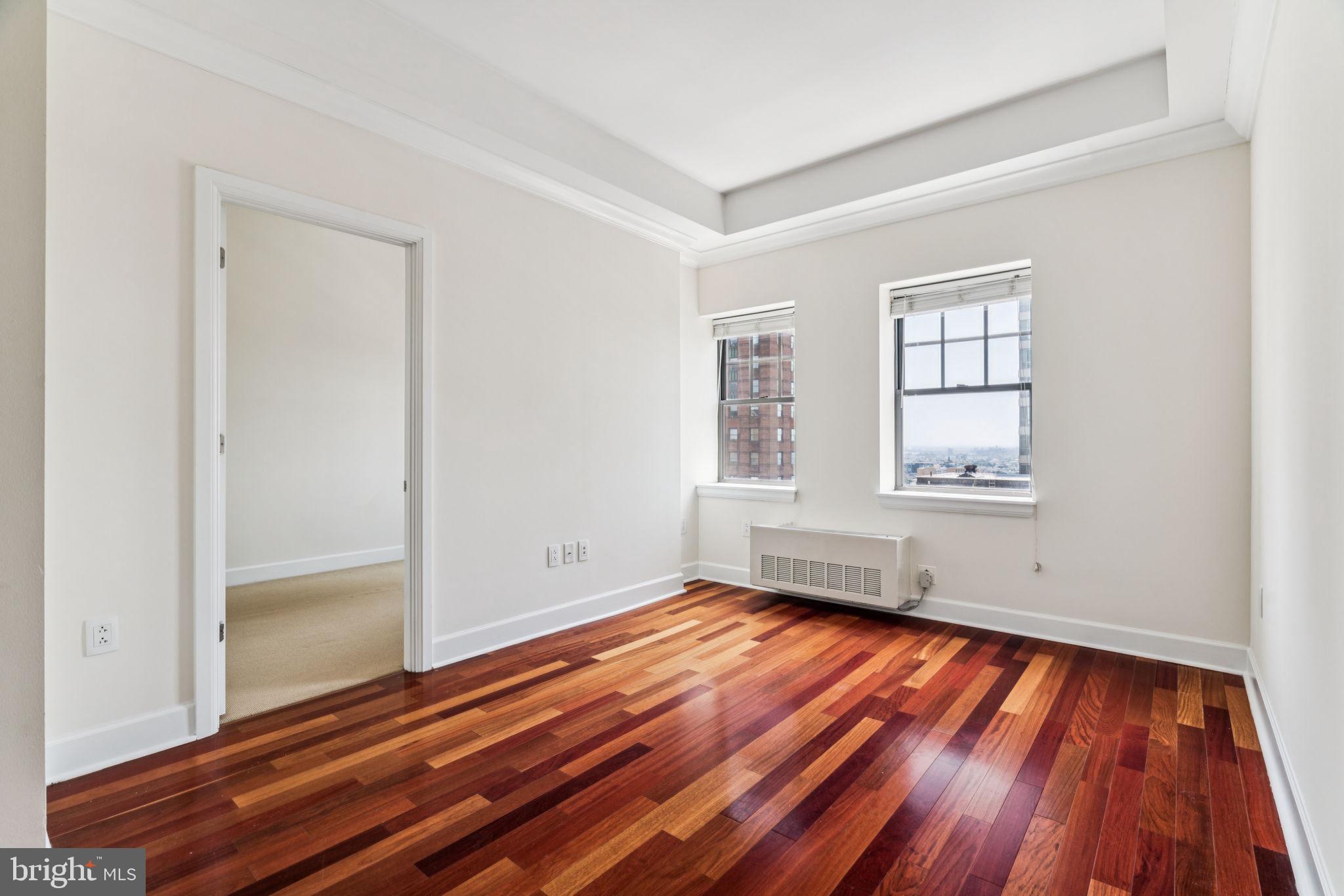 1701 Locust Street, Unit 2111 Philadelphia, PA 19103 - Photo 1 of 25 an empty room with wooden floor and windows