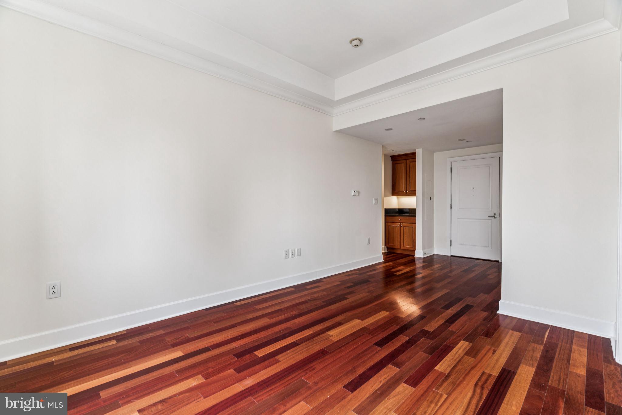 1701 Locust Street, Unit 2111 Philadelphia, PA 19103 - Photo 4 of 25 a view of an empty room with wooden floor and a window