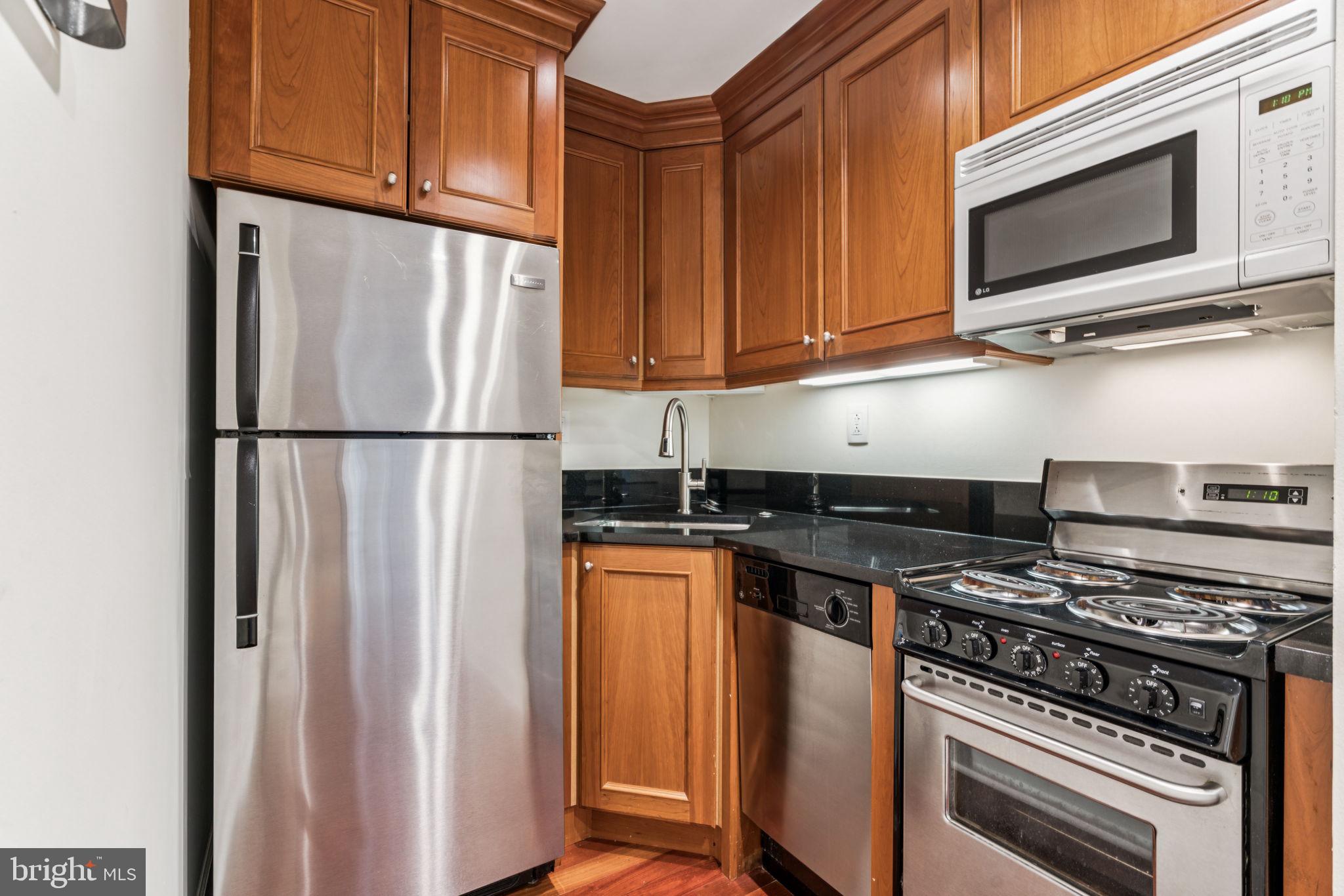 1701 Locust Street, Unit 2111 Philadelphia, PA 19103 - Photo 8 of 25 a kitchen with stainless steel appliances granite countertop a refrigerator stove and microwave