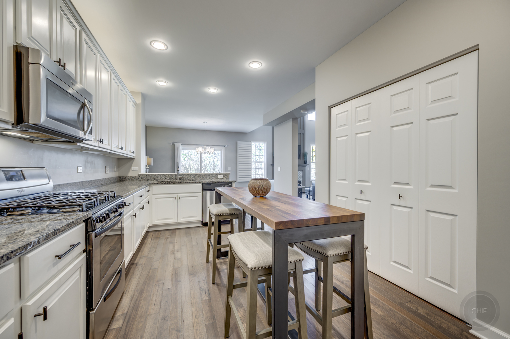 201 Dorset Avenue, Unit 201 Oswego, IL 60543 - Photo 12 of 41 a kitchen with stainless steel appliances granite countertop a stove top oven a sink dishwasher a dining table and chairs with wooden floor