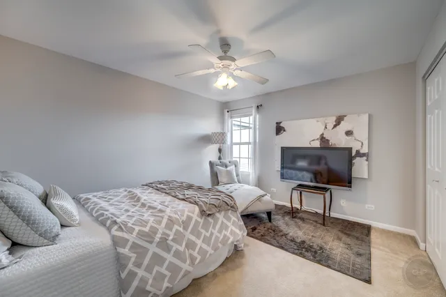 a bedroom with two large bed and a chandelier