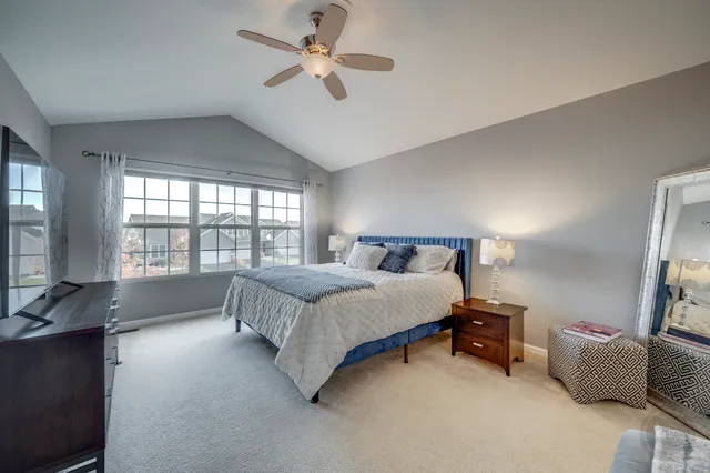a spacious bedroom with a bed and ceiling fan